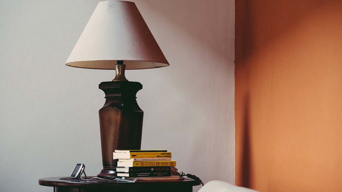 table lamp pile of books beside brown table lamp book
